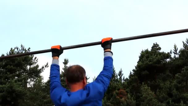 Man doing pull-ups outdoors — Stock Video