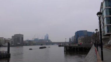 Thames Nehri kıyısındaki, Londra Köprüsü 'ndeki ve modern binalardaki insanların görüntüsü bulanık.
