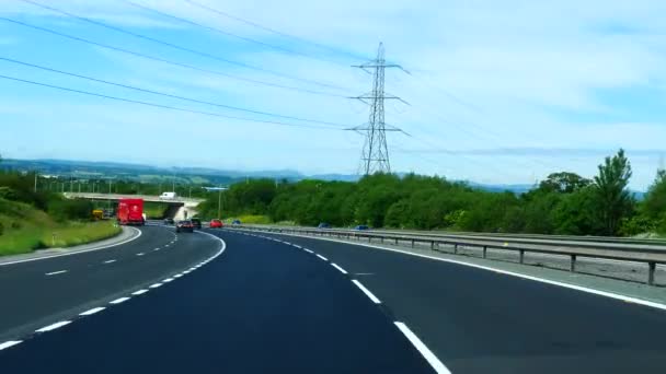 夏のイングランドとウェールズの国境の直前にA494高速道路の丘を運転する車のフロントウィンドウビュー — ストック動画