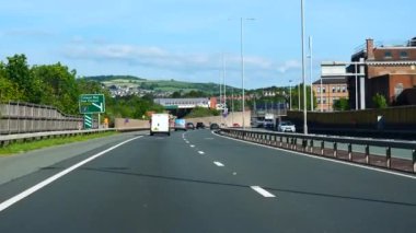 COLWYN BAY, WALES, BİRLİK KINGDOM - CRCA HAZİRAN 2021: Güzel güneşli bir yaz gününde Galler sahil beldesi kasabasında A55 karayolunu kullanan araba önü manzarası.