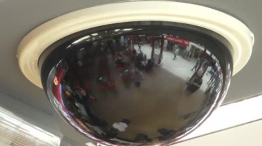 Tavanda hareket eden insanların bulanık yansımalarını gösteren siyah güvenlik kamerası baloncuğunu kapat.