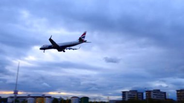 LONDON, ENGLAND, UNITED KINGDOM - Nisan 2017: British Airways uçağı Londra Şehir Havaalanına gece indi, finans bölgesi gökdelenleri arka planda görüldü.