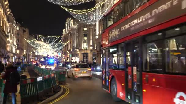 ロンドン イギリス Circa 11月 2020 すべての種類の交通機関は 夜にリージェントストリートで静的なカメラPovを通過 緊急照明が点滅して警察の車 ダブルデッキバス 自転車ライダーなど — ストック動画