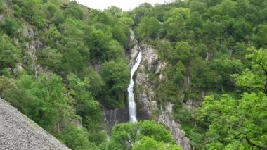 Kuzey Galler 'deki Aber Falls şelalesinde yeşil manzara, aşağı eğimli çekim kuruyor..
