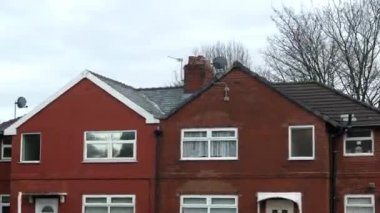 Salford, Greater Manchester, İngiltere 'deki tipik teraslı ve yarı teraslı evler hareket halindeki otobüsün üst güverte penceresinden geçiyor..