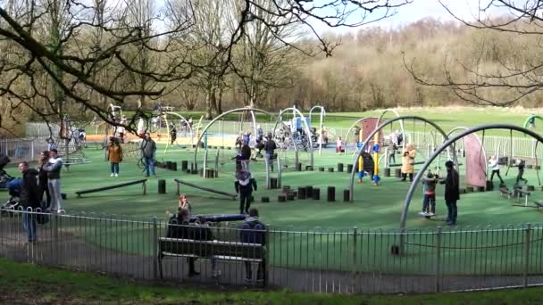 イギリス イングランド ファーンワース 2022 モーゼスゲートカントリーパークの遊び場で春の日を楽しむ子供連れの家族 — ストック動画