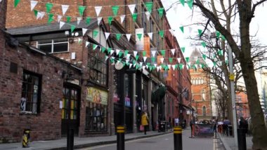 MANCHESTER, İngiltere, BİRLİK KINGDOM - 03.24.2022: St Patrick Günü için dekore edilmiş Canal Street restoranında bahar zamanının tadını çıkaran insanlar, beyaz yeşil kiraz kuşlarıyla yürüyen turistler.