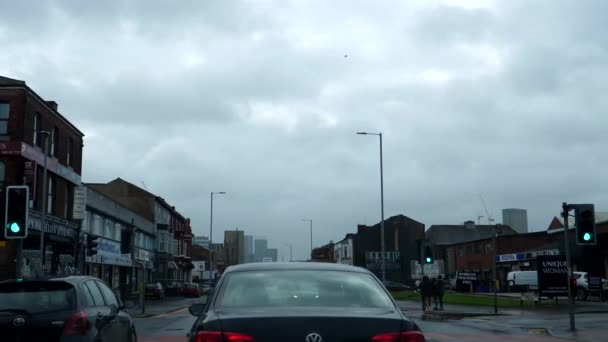 イギリスのマンチェスター Cheetham Hill Roadで右折する前に信号機を運転し停止する 霧雨の中でのフロントガラスの景色 — ストック動画