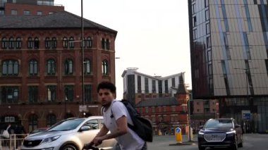 MANCHESTER, ENGLAND, UNITED KINGDOM - 03.24.2022: Kamera bakış açısı, POV; Çerçevenin ortasında görülen şehir yolu hanı; modern ve eski mimari.