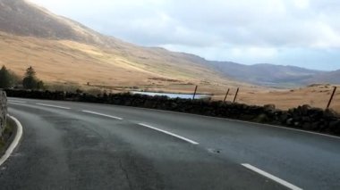 Kuzey Galler 'deki Snowdonia Ulusal Parkı' nın güzel bir sonbahar manzarasında A4086 yolunu kullanan araba önü manzaralı..