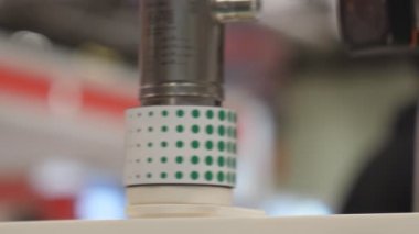 Otomatik üretim hattının bulanık görünümü; lazer flaş, sensör hareket eden ürünleri sayma; ön plana seçici odaklanma.
