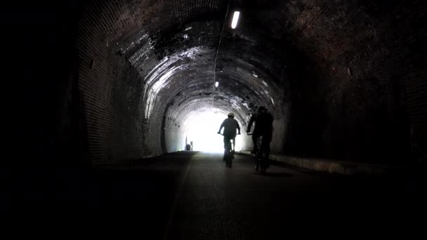 Siluetas Dos Ciclistas Irreconocibles Desaparecen Luz Brillante Final Del Túnel — Vídeos de Stock