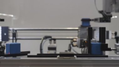Blurred, defocused view of parts being moved on automated production line, backgrounds.