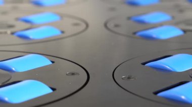 Close up of blue empty conveyor or transporter rollers, wheels spinning and changing load direction by simultaneously turning.