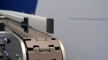 Empty narrow conveyor line moving, stopping and starting to move again, copy space.