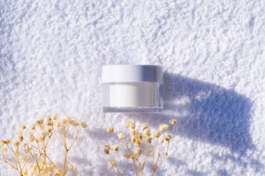 Beyaz bir havlunun arka planında beyaz cam kavanoz..