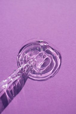 Pipette, yumuşak odak noktasında mor bir arka planda. Güneş ışığının güzel gölgesi.