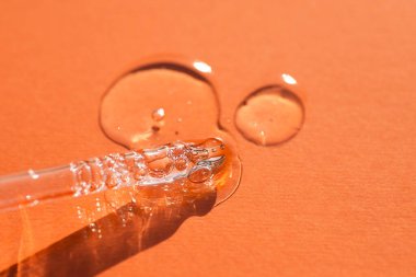 Pipette, yumuşak odak noktasında turuncu arka planda. Güneş ışığının güzel gölgesi.