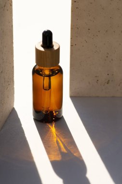 Kehribar cam damlatıcı şişesi ve taş kapaklı bambu kapağı. Cilt kozmetik.