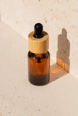 Kehribar cam damlatıcı şişesi ve taş kapaklı bambu kapağı. Cilt kozmetik.