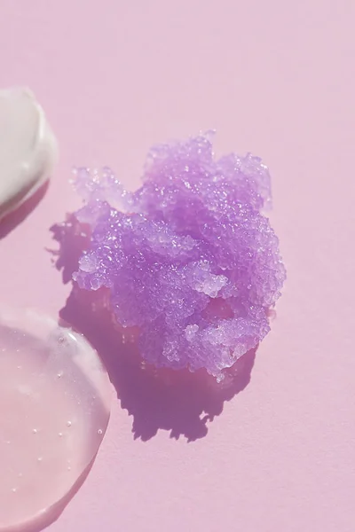 Apparence de la texture du gommage au sucre lilas sur fond rose. Frottis cosmétique. — Photo