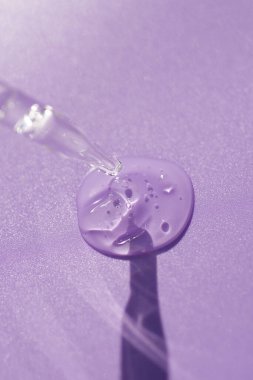 Pipette, yumuşak odak noktasında mor bir arka planda. Güneş ışığının güzel gölgesi.