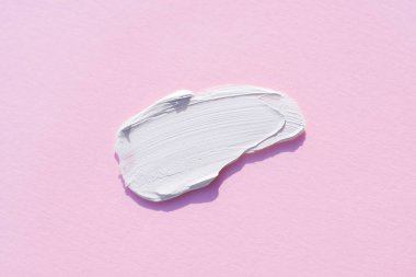 Krem lekesi ya da yüz maskesi. Kremin pembe arka planda görünümü.