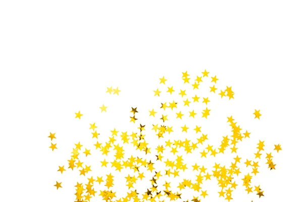 Confete dourado na forma de estrelas isoladas sobre fundo branco. Dia festivo pano de fundo. — Fotografia de Stock