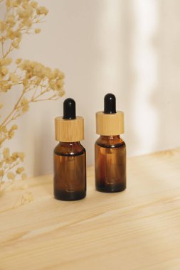 Kehribar şişeleri serumla ya da doğal ahşap arka planda gün ışığında gerekli yağla.