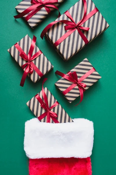 Striped Craft Gift Boxes Red Ribbon Santa Socks Green Background — Stock Photo, Image
