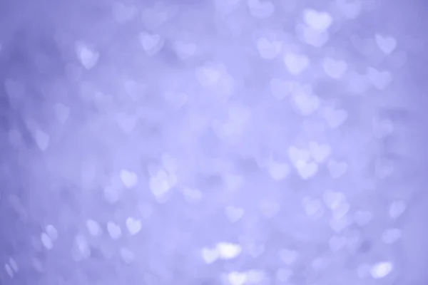 Přirozený purpurový bokeh světel v podobě srdce, rozmazaný z ohniskového pozadí. — Stock fotografie