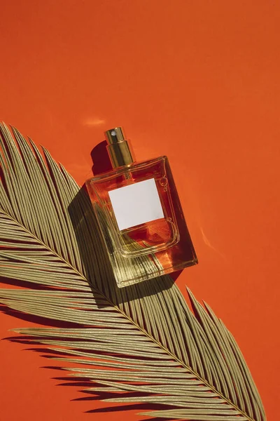 Frasco Transparente Perfume Con Etiqueta Sobre Fondo Naranja Presentación Fragancias — Foto de Stock