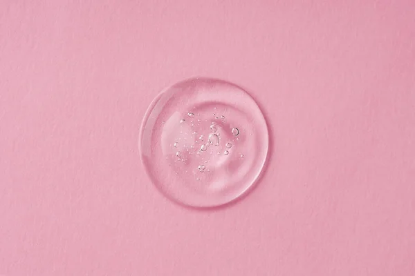 透明滴滴化妆品血清凝胶 具有粉色背景气泡的液体质感 护肤产品 天然化妆品 面部和身体护理的美感概念 — 图库照片