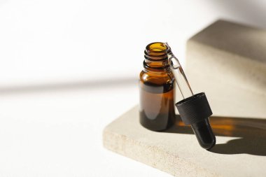 Damla pipetli kehribar cam şişeyi serumla ya da ürün sunumu için beton tabakta gerekli yağla açın. Cilt bakımı kozmetik. Yüz bakımı için güzellik konsepti