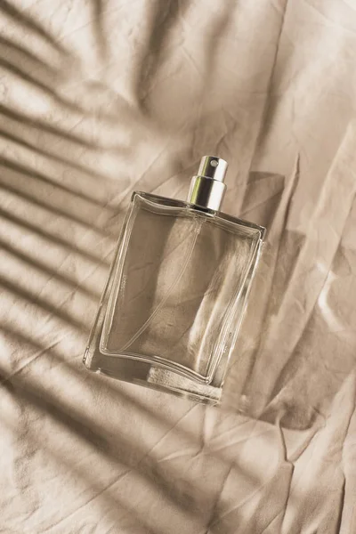 透明的瓶装香水 浅灰面料背景 带有日光和棕榈叶阴影的芬芳呈现 天然材料的趋势概念 妇女和男子的本质 — 图库照片