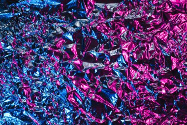 Mavi ve pembe alüminyum kırışık folyo arka plan. Yaratıcı eğilimi yansıtan soyut parlak doku. Açık neon fütüristik renkler. Ekranlar, web sitesi, el ilanları ve broşürler için renkli parlayan arkaplan