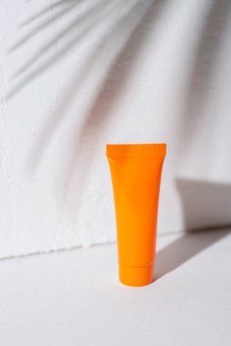 Beyaz arka planda krema ya da losyon için plastik turuncu şişeler. Güzel palmiye gölgeli cilt kozmetiği. Yüz bakımı için güzellik konsepti. Metin için yer