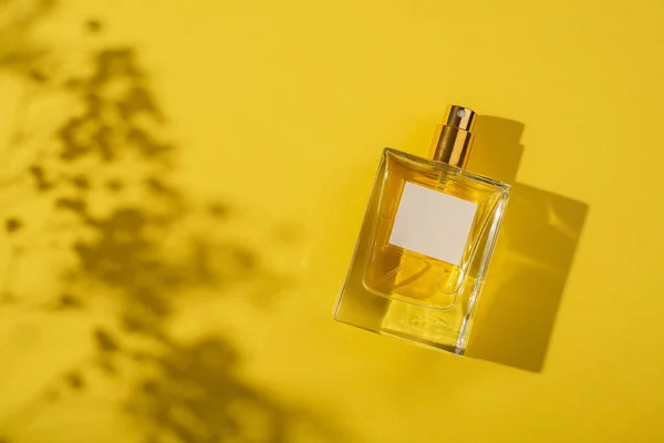透明的香水瓶 带有黄色背景的标签 光天化日下的芬芳呈现具有窗体阴影的天然材料的趋势概念 妇女的本质 — 图库照片