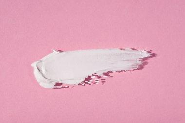 Krem lekesi ya da yüz maskesi. Kremin pembe arka plandaki dokusunun görünümü. Cilt bakım ürünleri, doğal kozmetik ürünleri. Yüz ve vücut bakımı için güzellik konsepti
