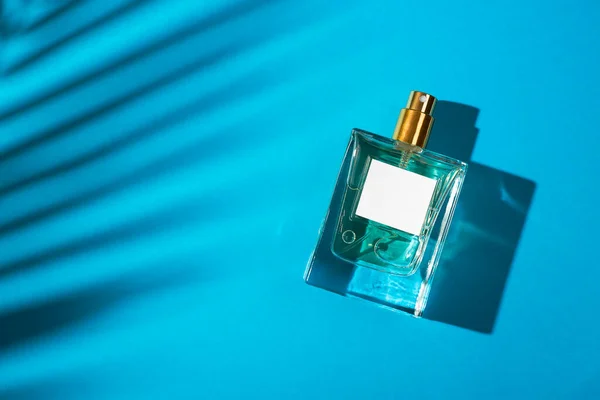 Transparante Fles Parfum Met Etiket Blauwe Achtergrond Parfumpresentatie Met Daglicht — Stockfoto