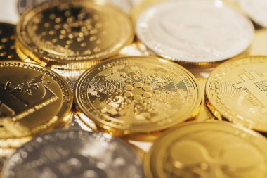 Diğer madeni paraların arka planına karşı Cardano altın sikkesi. Çevrimiçi bankacılık için elektronik sanal şifreli para birimi. İş para birimi teknolojisi kavramı.
