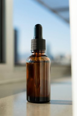 Krem için pompalı plastik beyaz şişeler ya da pencere kenarında losyon. Güzel gölgeli cilt bakımı kozmetiği. Yüz bakımı için güzellik konsepti. Bokeh ile penceredeki şehrin bulanık arkaplanı