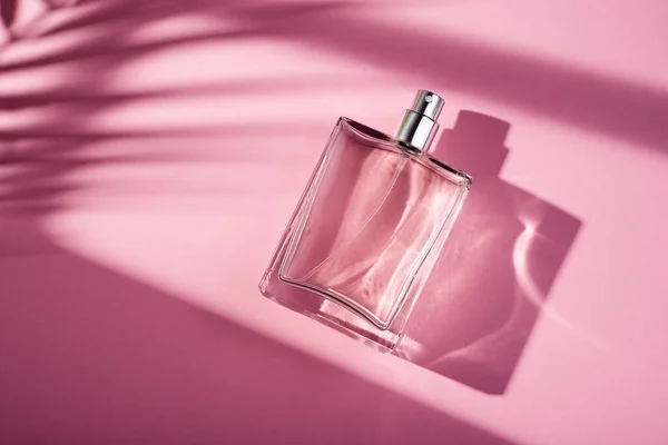 粉色背景的透明香水瓶 光天化日下的芬芳呈现具有窗体阴影的天然材料的趋势概念 妇女的本质 — 图库照片