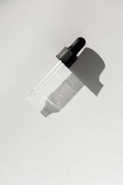 Damlalık pipetle serumla kapağı aç. Işık arka planı, gün ışığı ve jel dokusunun görünüşü. Kincare ürünleri, doğal kozmetik. Yüz ve vücut bakımı için güzellik konsepti