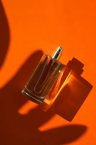 Frasco Transparente Perfume Sobre Fondo Naranja Presentación Fragancias Con Luz — Foto de Stock