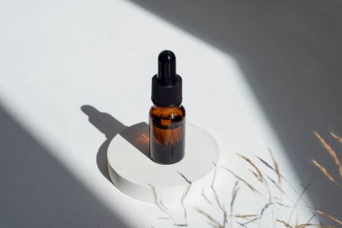 Kehribar cam damlaları siyah kapaklı ve beyaz beton podyumda ürün sunumu için gerekli ya da gerekli yağlı. Cilt kozmetiği. Yüz bakımı için güzellik konsepti