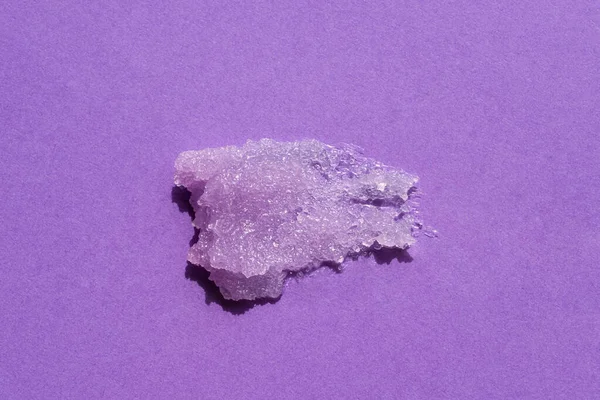 Sugar body scrub texture on a purple background. Cosmetic smear. Appearance of the texture of the lilac swatch. Natural skincare products. Beauty concept for face and body care