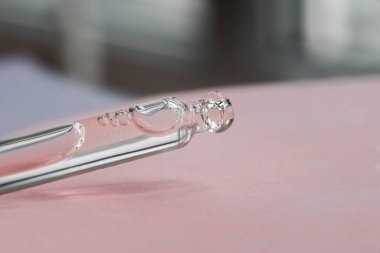 Serumlu ya da kozmetik sıvılı Pipette ürün sunumu için yumuşak odaklı pembe beton plaka. Cilt bakım ürünleri, doğal kozmetik ürünleri. Yüz için güzellik konsepti