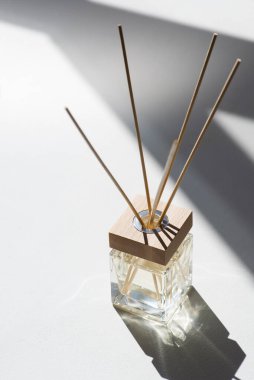 Beyaz arka planda şeffaf aroma yayıcı şişesi. Ev yapımı sunum için parfüm. Eğilim kavramı