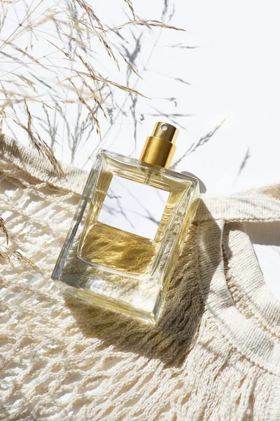 透明的香水瓶与标签和布袋 野花与白色背景 光天化日下的芬芳呈现天然材料的趋势概念 妇女和男子的本质 — 图库照片